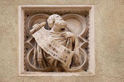 Low angle view of angel statue against wall