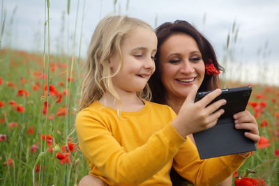 Portrait of smiling girl holding smart phone outdoors