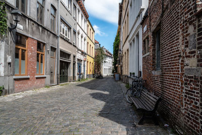 Footpath amidst buildings against sky