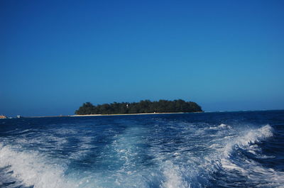 Scenic view of sea against clear blue sky