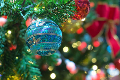 Close-up of blue christmas ornament hanging on tree