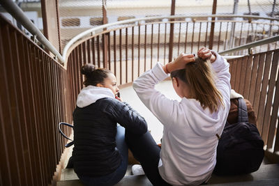 Male and female teenage friends sitting on steps