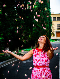 Happy young woman with arms raised