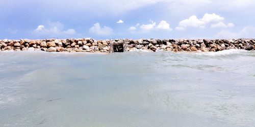 Panoramic view of rocks in sea against sky