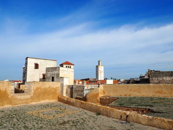 Lighthouse by sea against sky