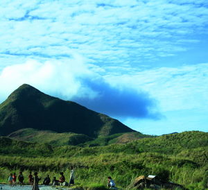 People on mountain against sky