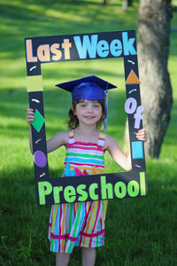 Portrait of a smiling girl standing on field