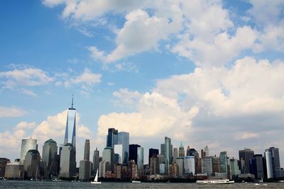 Skyscrapers in city against cloudy sky