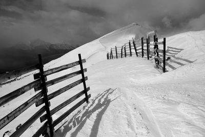 High angle view of fence on snowcapped mountains against sky during sunny day