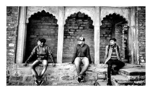 People sitting outside historic building