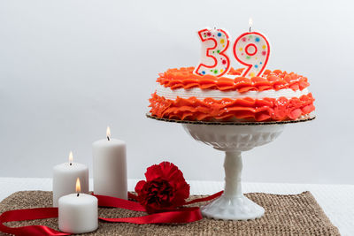 Close-up of red cake on table against gray background