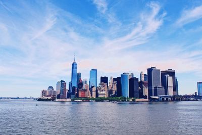 Scenic view of river by buildings against sky