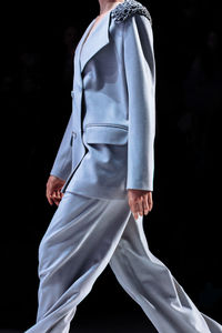 Elegant blue gray pants and jacket, woman's chic outfit on black background