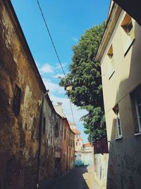 Narrow alley amidst residential buildings against sky