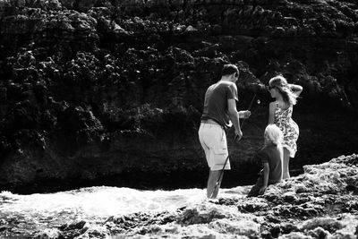 Family by stream in sunny day