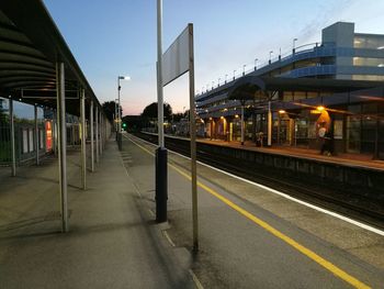 Train at railroad station in city against sky