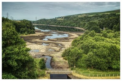 High angle view of low reservoir against sky