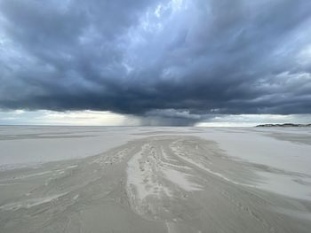 Scenic before storm  view of beach against cloudy sky