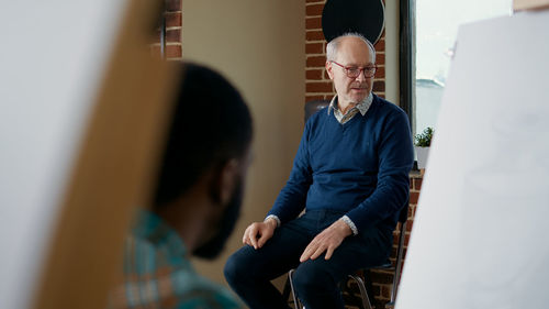 Senior man sitting on stool