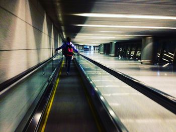 Rear view of man moving on subway station