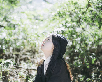 Side view of young woman looking up