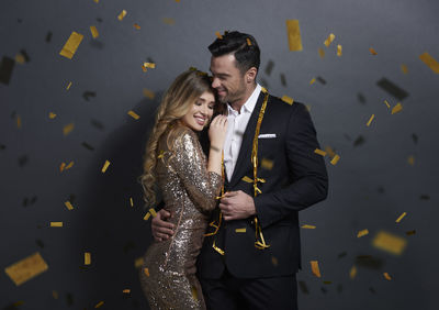 Couple embracing amidst confetti in party