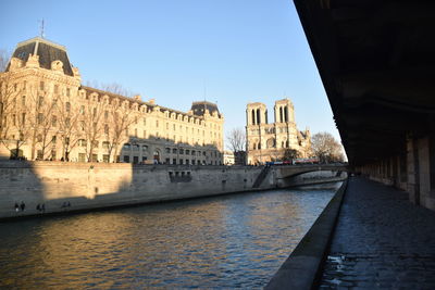 Bridge over river against sky in city
