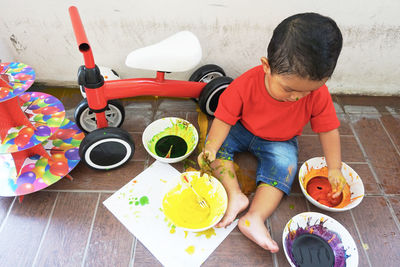 Cute boy playing with watercolors paint at home