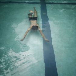 Low section of man swimming in pool