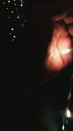 Close-up of hand holding illuminated light at night