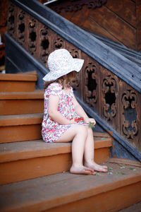 Low angle view of girl sitting on staircase