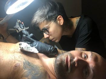 Portrait of man getting tattoo on body