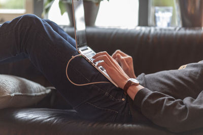 Low section of man sitting on sofa