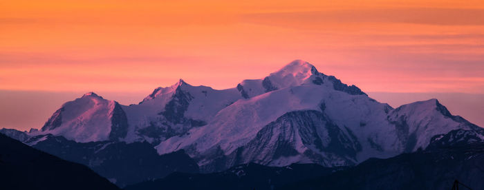 Scenic view of snowcapped mountains during sunset