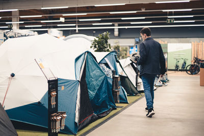 A young man examines the tents in the store.