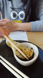 Midsection of woman having asian food on table