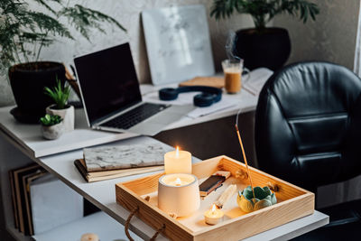 Work life balance. mental health, mindfulness, wellbeing. home workplace table with laptop, burning