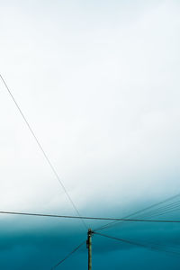 Low angle view of electricity pylon against clear sky