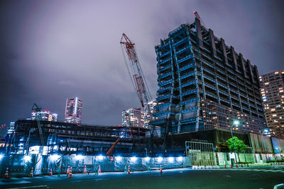 Illuminated buildings against sky at night