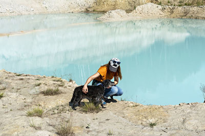 People sitting on rock by water