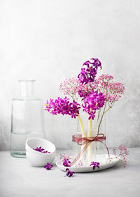 Still life with flower bouquet of fresh purple hyacinth, and pink gypsophila flowers in a glass vase