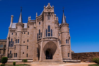 Low angle view of historical building against clear blue sky