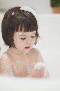 Close-up portrait of cute baby girl in bathroom