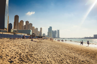 Panoramic view of people on beach against sky