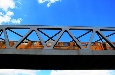 Low angle view of train on railway bridge against sky