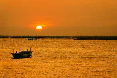 The sunset at  the oyster farm and the little boat. scenic view of sea against sky during sunset