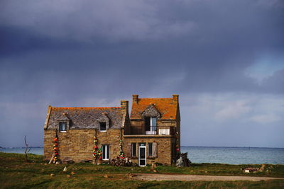 Building by sea against sky