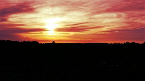 Scenic view of silhouette landscape against orange sky