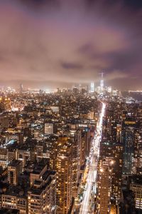 High angle view of illuminated buildings against sky at night