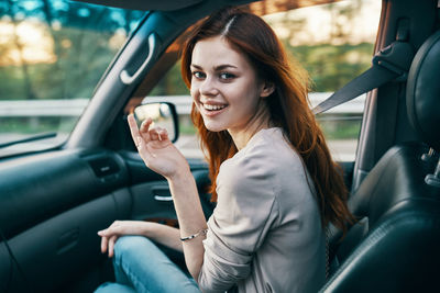 Portrait of smiling woman sitting in car